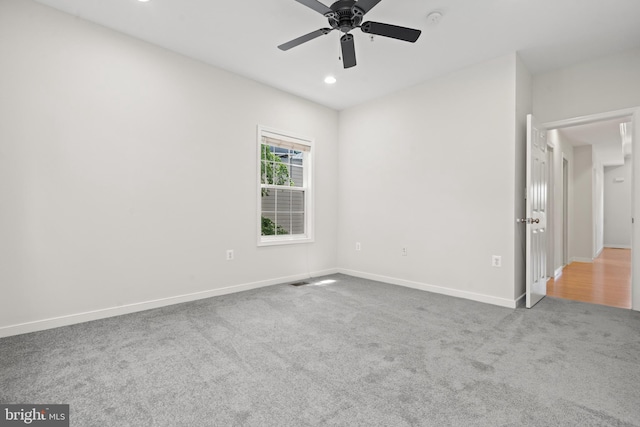 carpeted spare room featuring ceiling fan