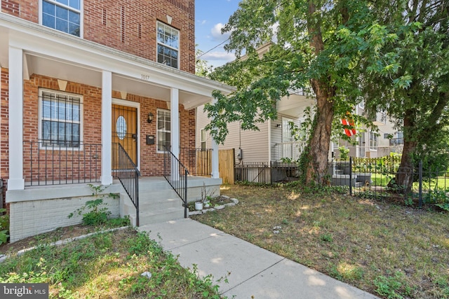 doorway to property featuring a yard and a porch