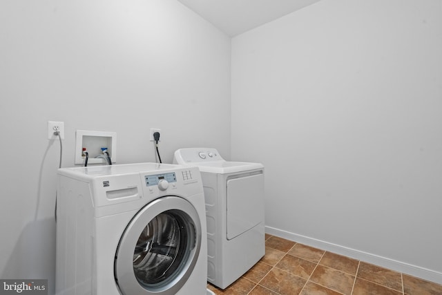 clothes washing area with washer and dryer and dark tile patterned flooring