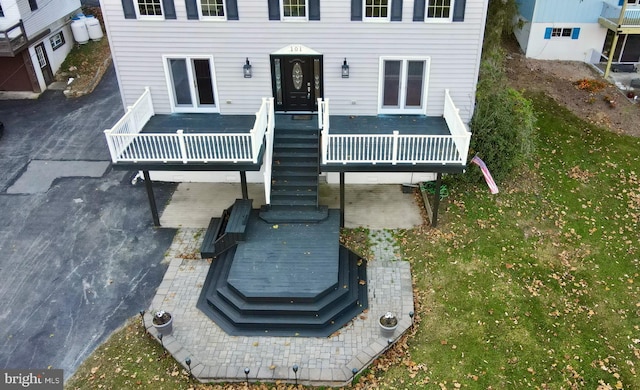 back of property with a wooden deck, a yard, and a patio area