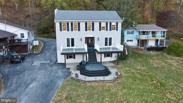 view of front of house with a balcony and a front yard