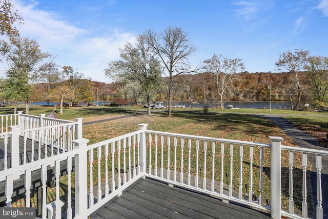 deck featuring a water view and a lawn