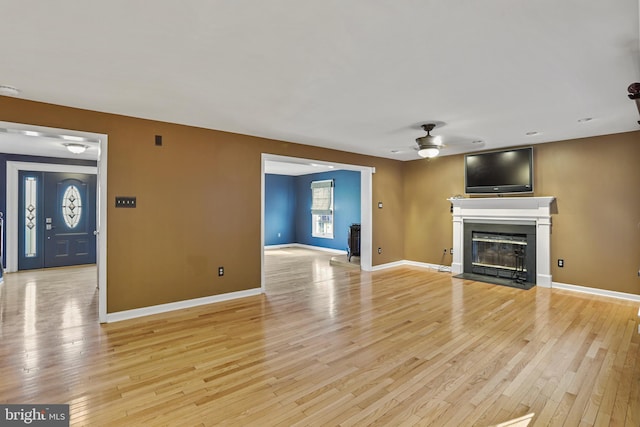 unfurnished living room featuring light wood-type flooring and ceiling fan