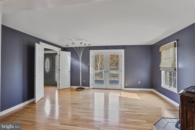 spare room featuring light hardwood / wood-style flooring and french doors