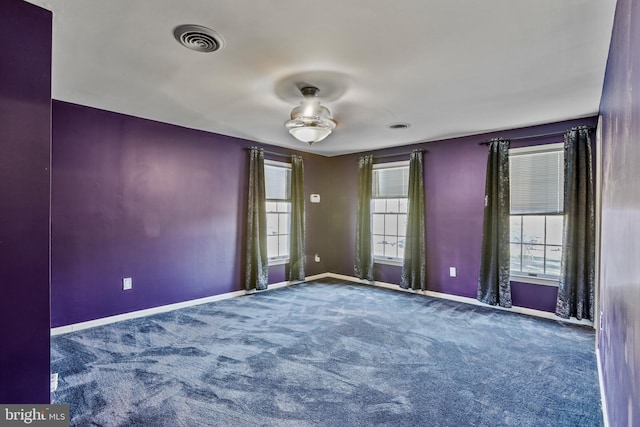 carpeted empty room with ceiling fan and a healthy amount of sunlight