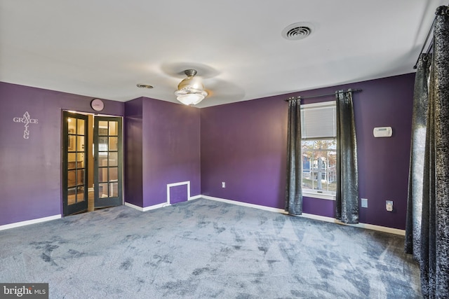 carpeted empty room with ceiling fan and french doors