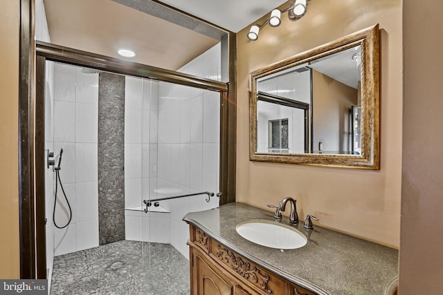 bathroom with a shower with shower door and vanity