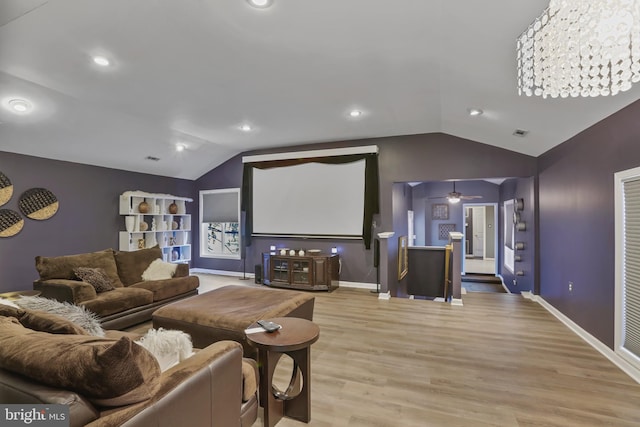 cinema with ceiling fan, light hardwood / wood-style flooring, and vaulted ceiling