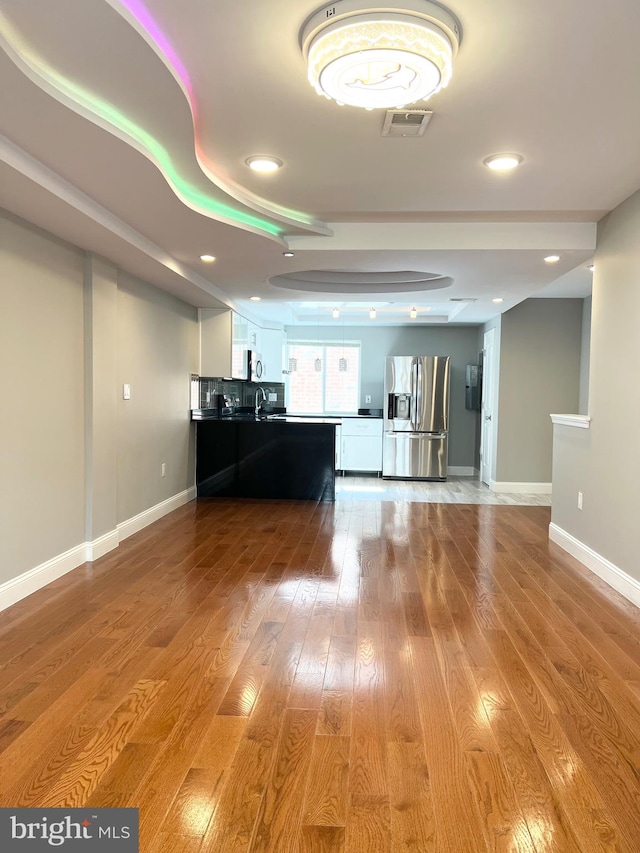 unfurnished living room featuring sink and light wood-type flooring