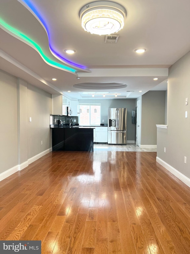 unfurnished living room with light hardwood / wood-style flooring and sink