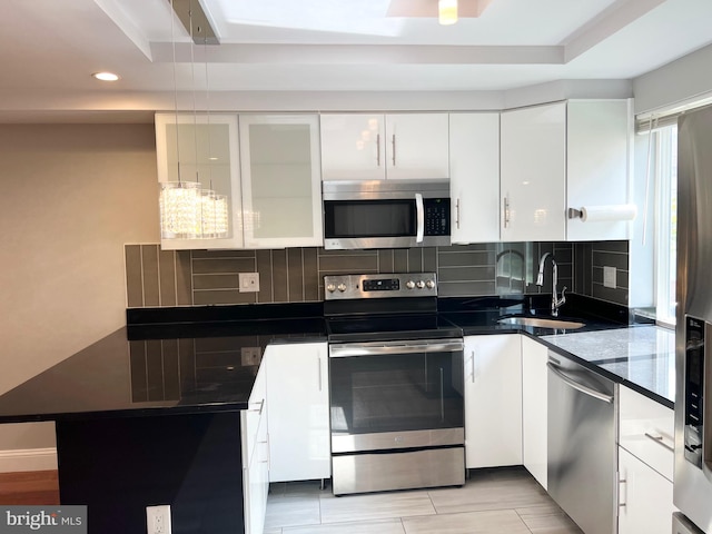 kitchen featuring light hardwood / wood-style flooring, stainless steel appliances, sink, white cabinetry, and tasteful backsplash