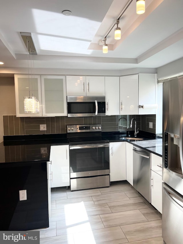 kitchen with white cabinetry, tasteful backsplash, appliances with stainless steel finishes, and decorative light fixtures