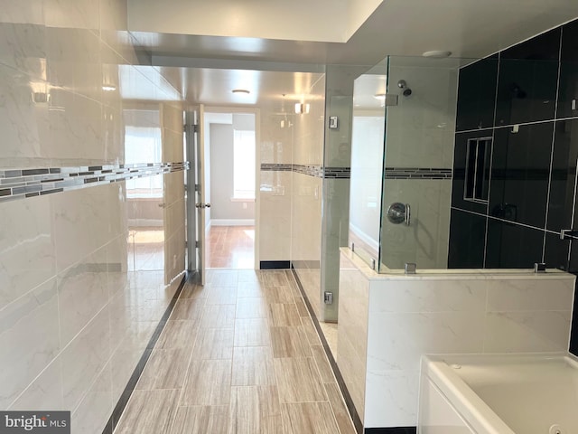 bathroom featuring tile walls and plus walk in shower