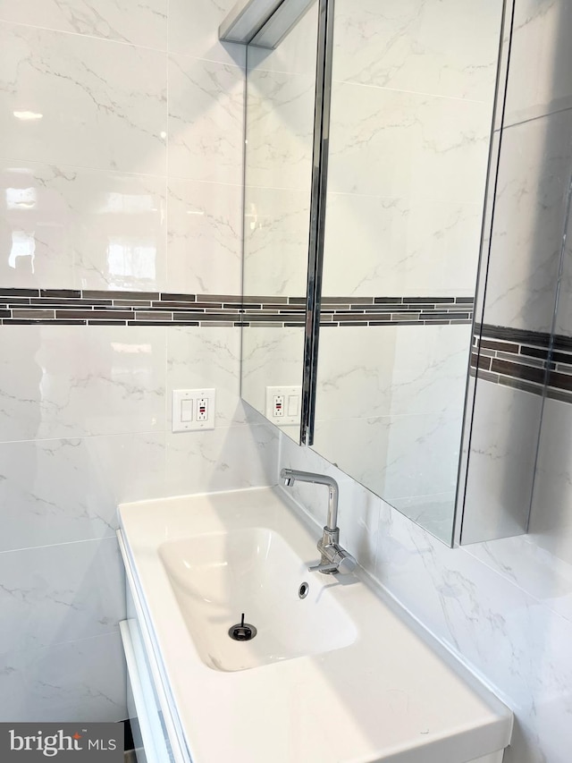 bathroom with vanity and tile walls