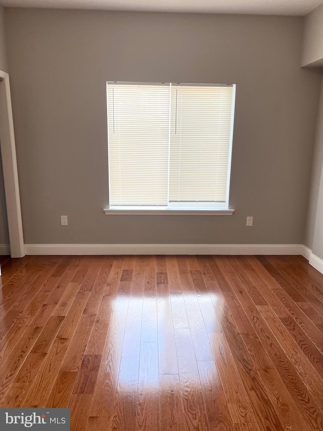 unfurnished room with wood-type flooring