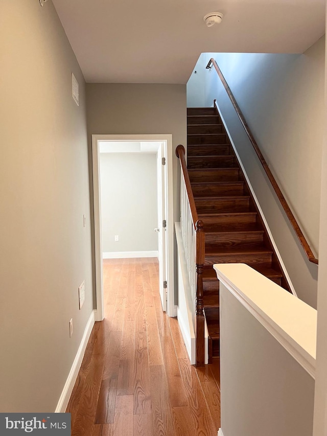 staircase with hardwood / wood-style flooring