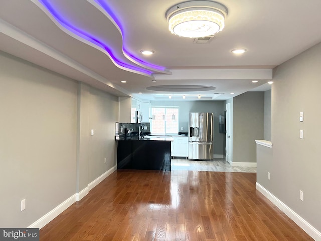 kitchen featuring white cabinetry, sink, light wood-type flooring, and stainless steel refrigerator with ice dispenser