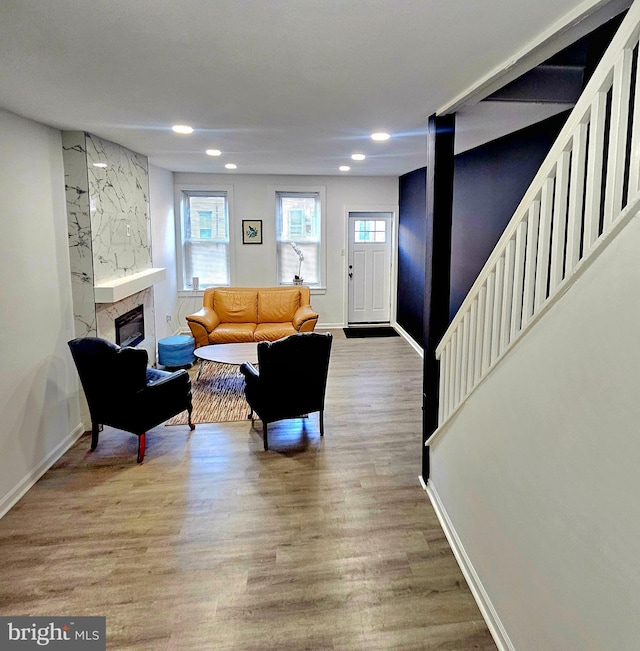 living room with hardwood / wood-style floors and a high end fireplace