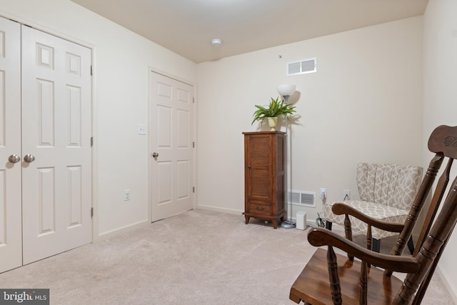 sitting room featuring light carpet