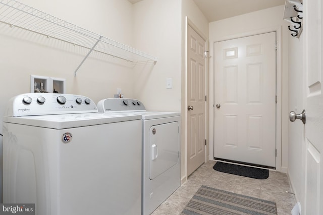 clothes washing area featuring light tile patterned floors and independent washer and dryer