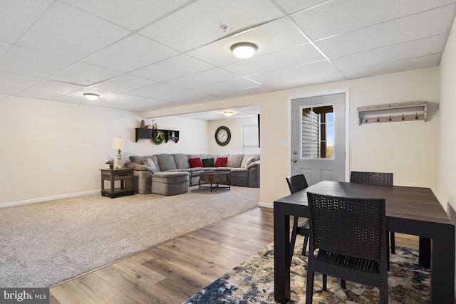 dining space with a drop ceiling and hardwood / wood-style flooring