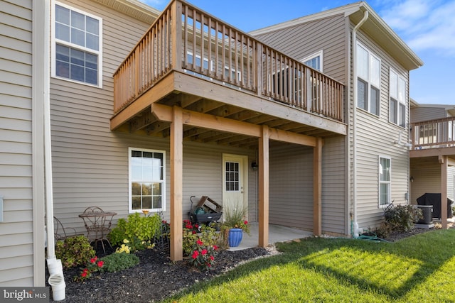 rear view of property featuring a lawn and a wooden deck
