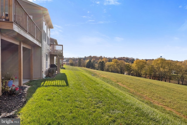 view of green lawn with a balcony