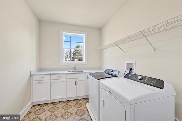 laundry room with cabinets, light tile patterned floors, washing machine and dryer, and sink