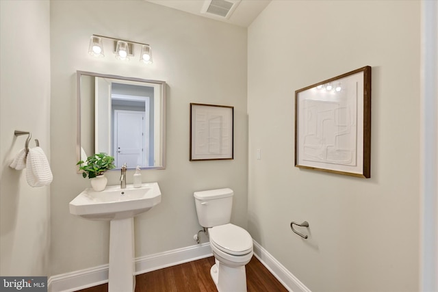 bathroom with wood-type flooring and toilet