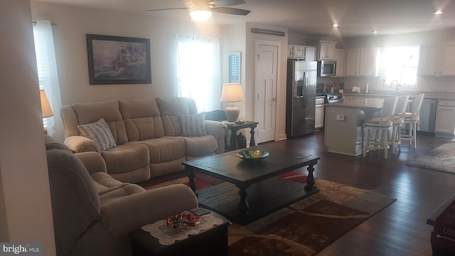 living room with ceiling fan and dark hardwood / wood-style flooring