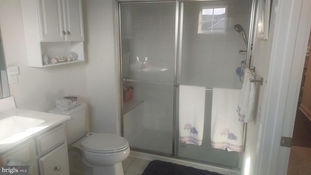 bathroom with a shower with door, toilet, tile patterned flooring, and vanity