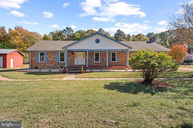 ranch-style home featuring a storage unit, a porch, and a front yard