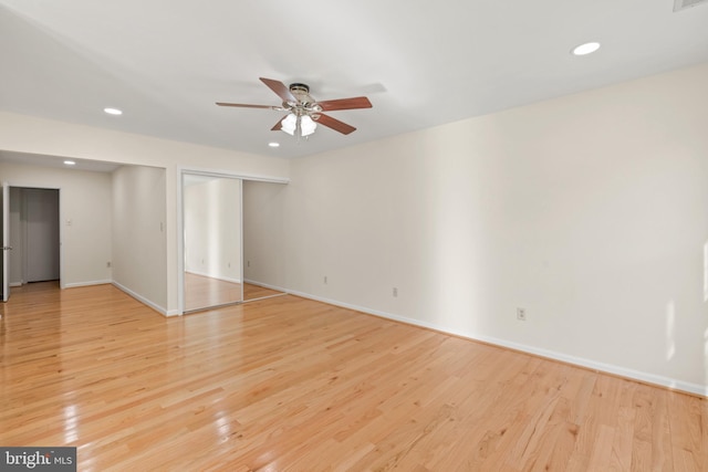 empty room with ceiling fan and light hardwood / wood-style floors