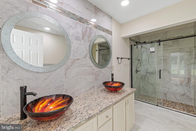 bathroom with vanity, walk in shower, and tile walls