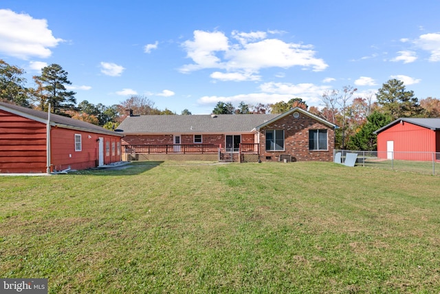 back of house featuring a wooden deck and a yard