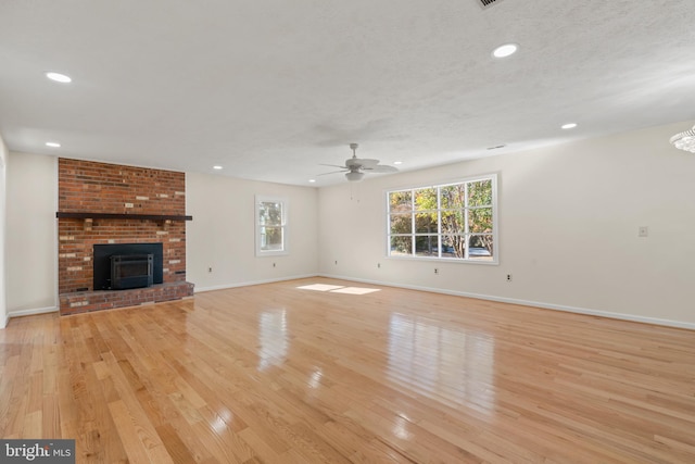 unfurnished living room with a textured ceiling, light hardwood / wood-style floors, and ceiling fan