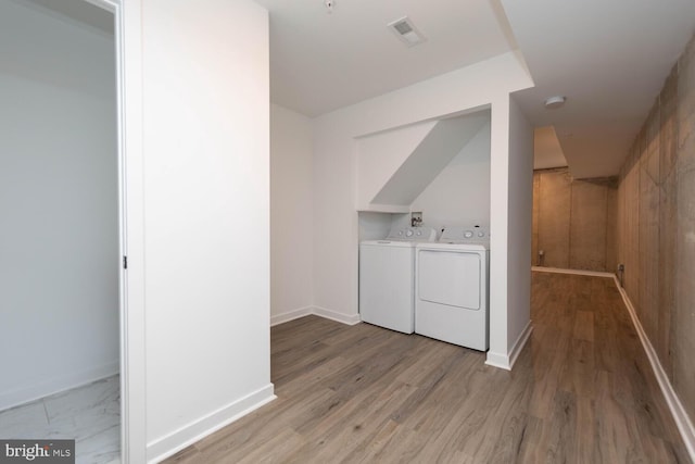 washroom featuring washing machine and dryer and light wood-type flooring