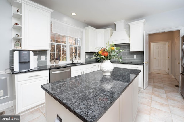 kitchen featuring tasteful backsplash, sink, white cabinets, dishwasher, and a center island