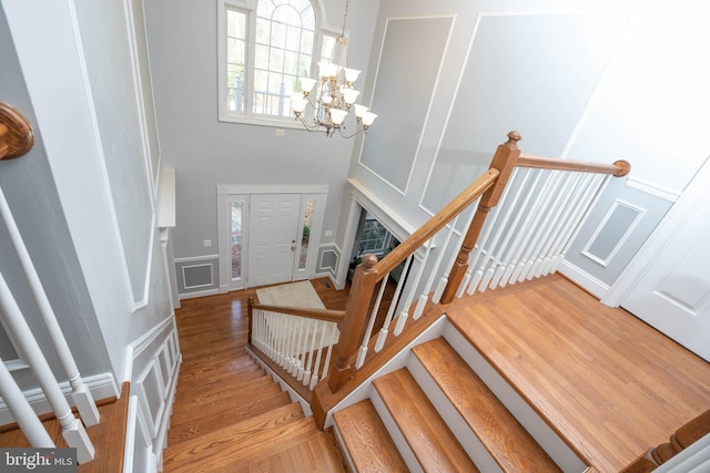 staircase featuring wood-type flooring and a notable chandelier