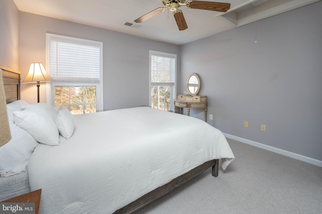 carpeted bedroom featuring ceiling fan and multiple windows