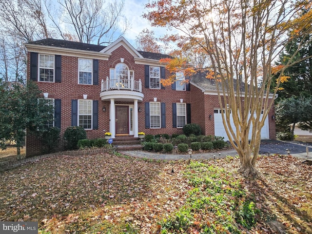 colonial home featuring a balcony and a garage