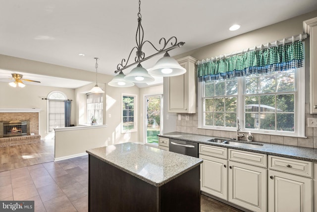 kitchen featuring tasteful backsplash, dark hardwood / wood-style flooring, light stone countertops, hanging light fixtures, and sink