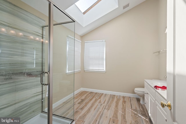 bathroom featuring a shower with door, vanity, toilet, hardwood / wood-style flooring, and lofted ceiling with skylight