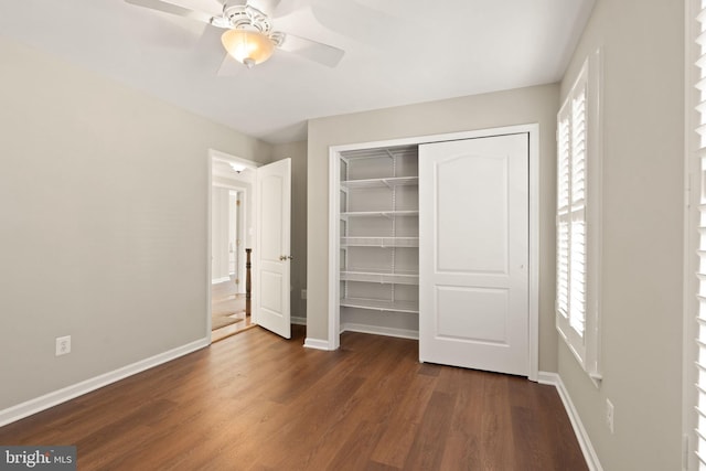 unfurnished bedroom with dark wood-type flooring, a closet, and ceiling fan