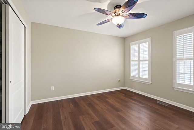 unfurnished bedroom featuring dark hardwood / wood-style flooring, a closet, and ceiling fan