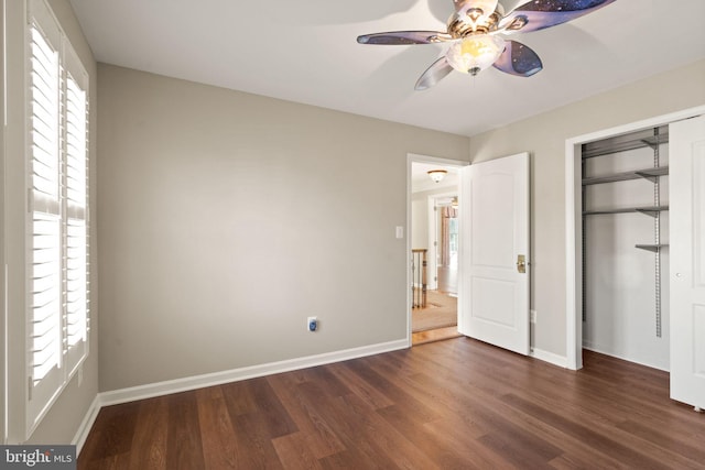 unfurnished bedroom featuring dark hardwood / wood-style flooring, ceiling fan, and a closet