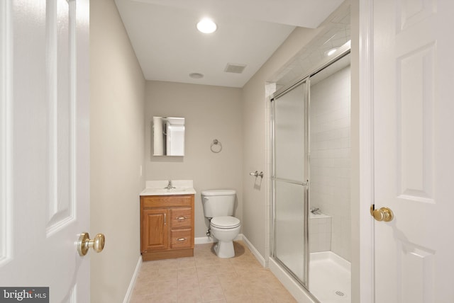 bathroom featuring toilet, vanity, tile patterned flooring, and a shower with door