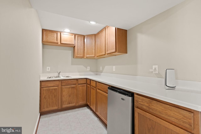 kitchen featuring sink, stainless steel refrigerator, and light tile patterned flooring