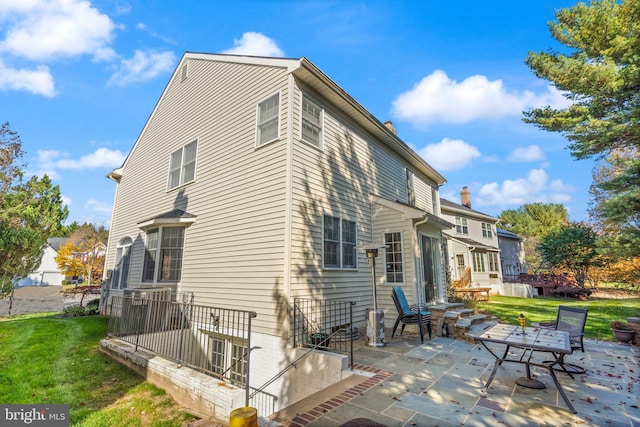 rear view of property with a patio and a yard