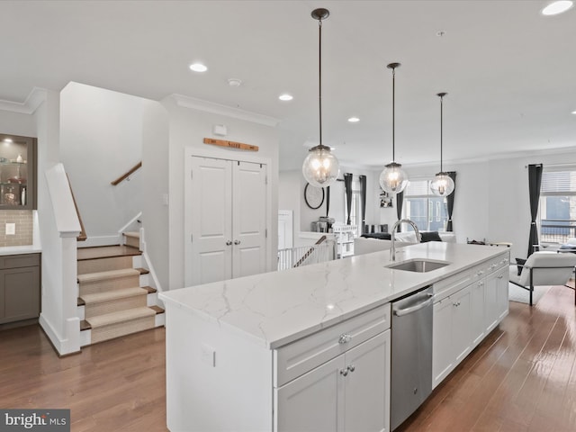 kitchen featuring dishwasher, dark hardwood / wood-style floors, a center island with sink, sink, and white cabinetry